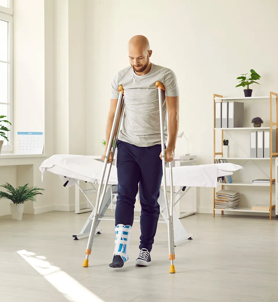 Man using crutches at a doctors office visit